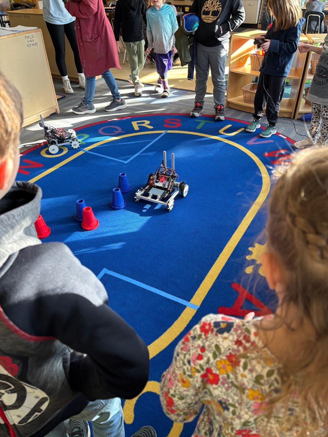 Kids watching a robot drive at an FLL event