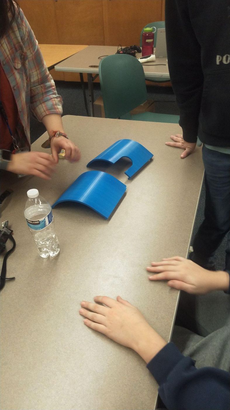 Two blue 3D-printed shooter ramps on a table
